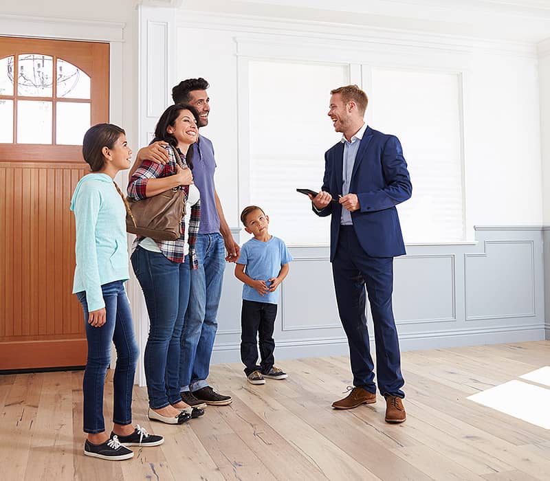 Makler zeigt junger Familie neue Immobilie